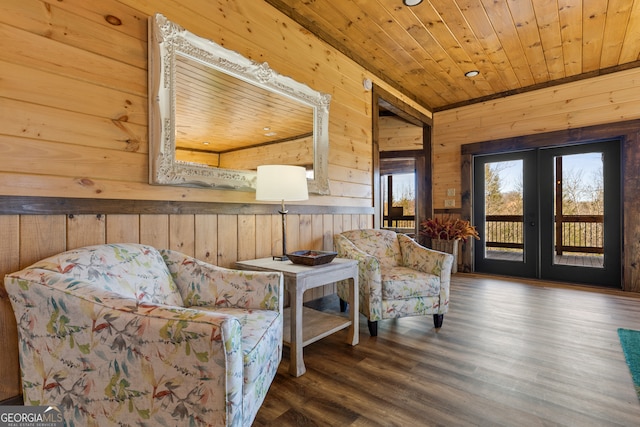 sitting room featuring wooden ceiling, wood walls, dark wood-type flooring, and french doors