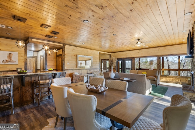 dining space featuring wooden walls, dark hardwood / wood-style floors, and wooden ceiling