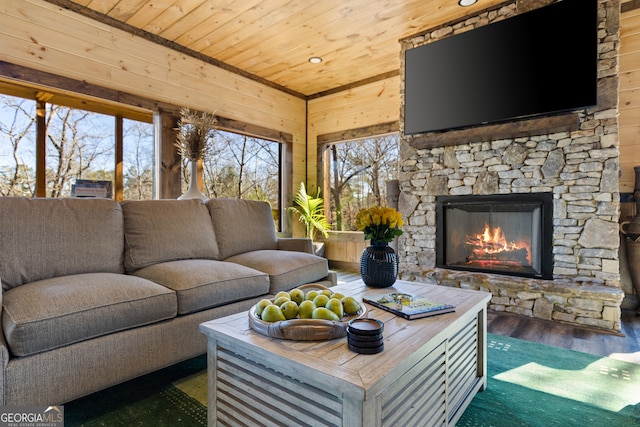 living room featuring a stone fireplace, dark hardwood / wood-style floors, wood walls, and wooden ceiling