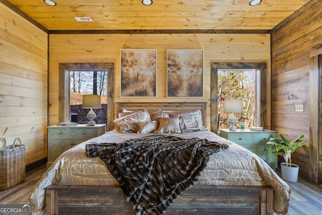 bedroom with wooden ceiling, wood-type flooring, and wood walls