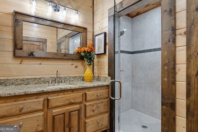 bathroom featuring wood walls, vanity, and a shower with shower door