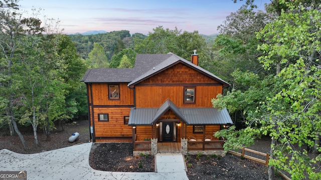 log home featuring covered porch