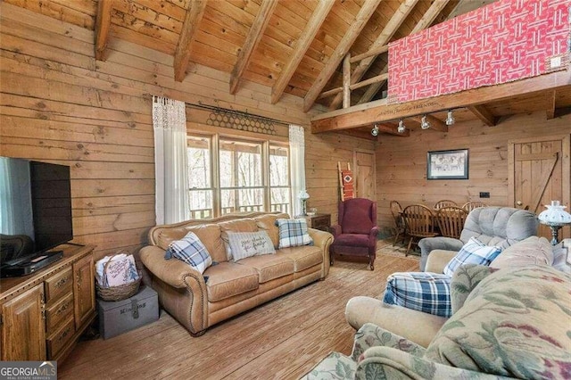 living room with lofted ceiling with beams, wooden walls, light hardwood / wood-style floors, and wooden ceiling