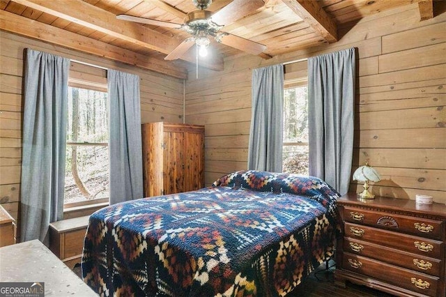 bedroom featuring ceiling fan, beamed ceiling, wood ceiling, and multiple windows