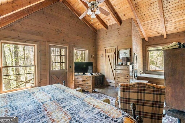 bedroom featuring multiple windows, wooden walls, dark hardwood / wood-style floors, and ceiling fan