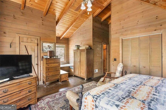 bedroom with wooden walls, beam ceiling, dark wood-type flooring, and a closet