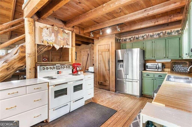 kitchen with light hardwood / wood-style floors, beamed ceiling, sink, green cabinetry, and stainless steel appliances