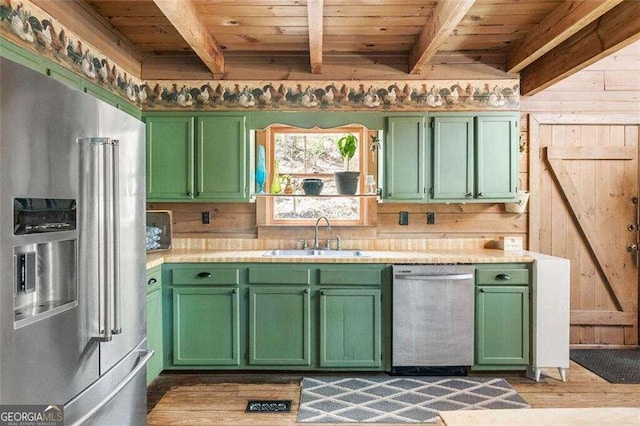 kitchen featuring light hardwood / wood-style flooring, stainless steel appliances, green cabinets, and sink