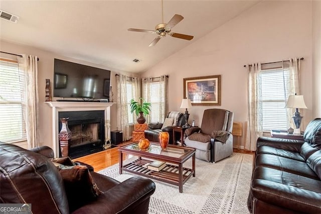 living room featuring ceiling fan, light hardwood / wood-style flooring, plenty of natural light, and high vaulted ceiling