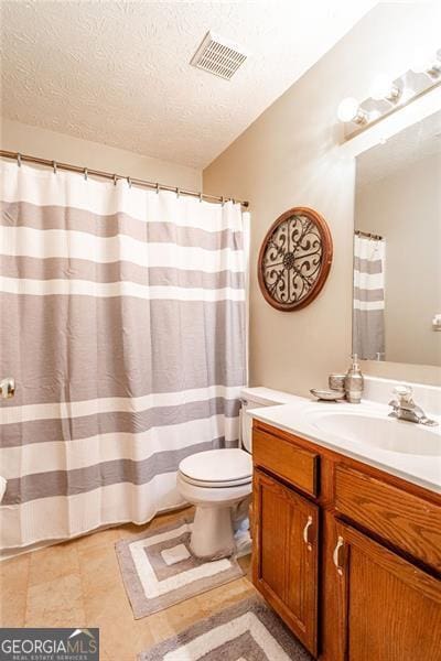 bathroom featuring a textured ceiling, vanity, and toilet