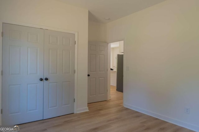 unfurnished bedroom featuring light hardwood / wood-style flooring and a closet