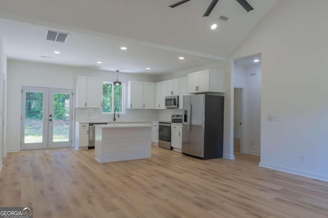 kitchen featuring ceiling fan, white cabinets, a kitchen island, light hardwood / wood-style flooring, and stainless steel appliances