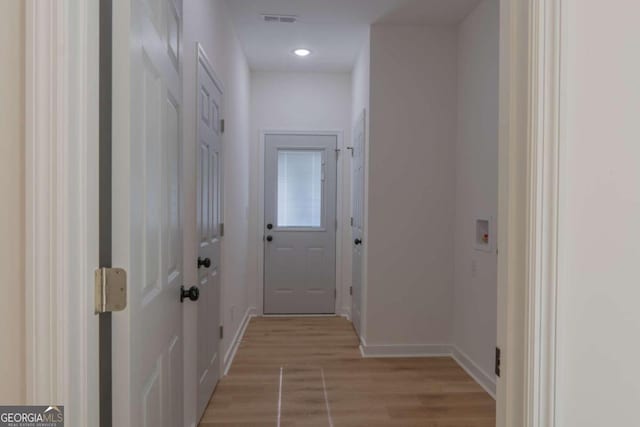 hallway with light hardwood / wood-style floors