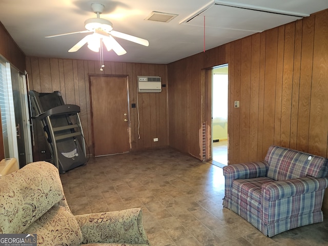 living room featuring wooden walls, ceiling fan, and a wall mounted AC