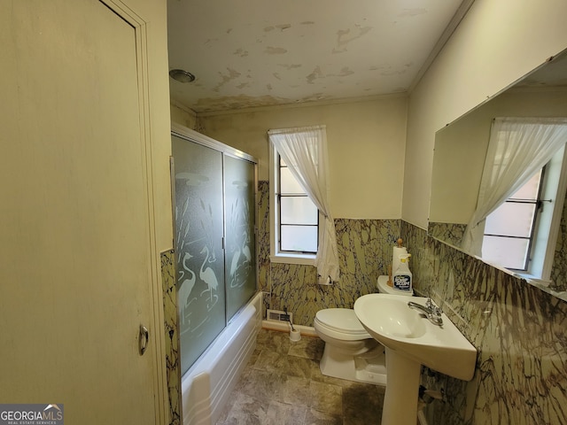 bathroom with enclosed tub / shower combo and toilet