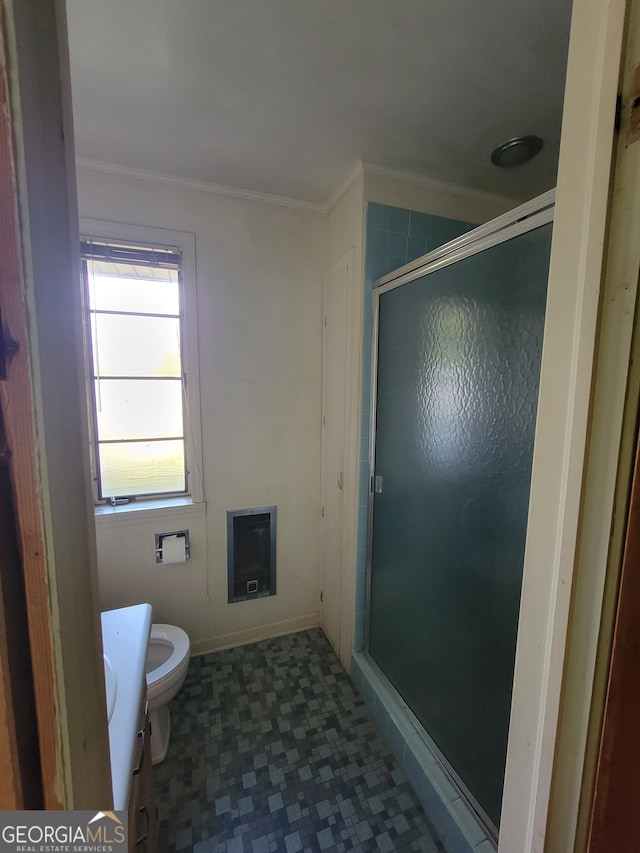 bathroom with vanity, ornamental molding, heating unit, a shower with shower door, and toilet