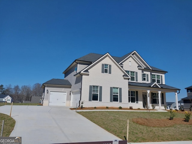 view of front of property featuring a garage, a front yard, and covered porch