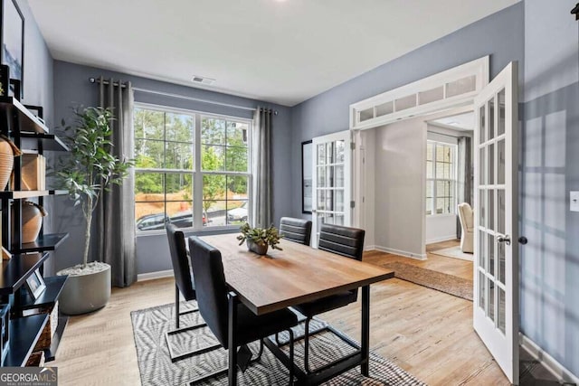 dining space with french doors and light hardwood / wood-style floors