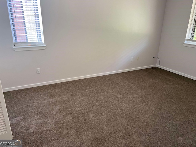 empty room featuring dark colored carpet