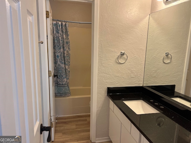 bathroom with vanity, shower / bathtub combination with curtain, and hardwood / wood-style flooring