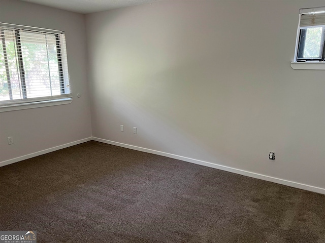 empty room featuring dark colored carpet