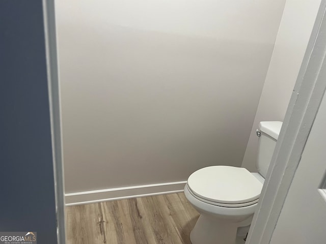 bathroom featuring hardwood / wood-style flooring and toilet