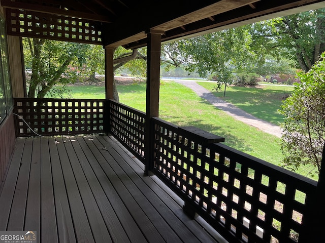 wooden deck featuring a lawn