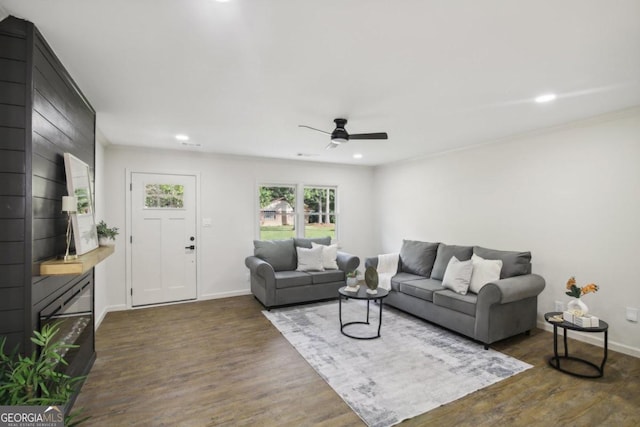 living room featuring ceiling fan and dark hardwood / wood-style flooring