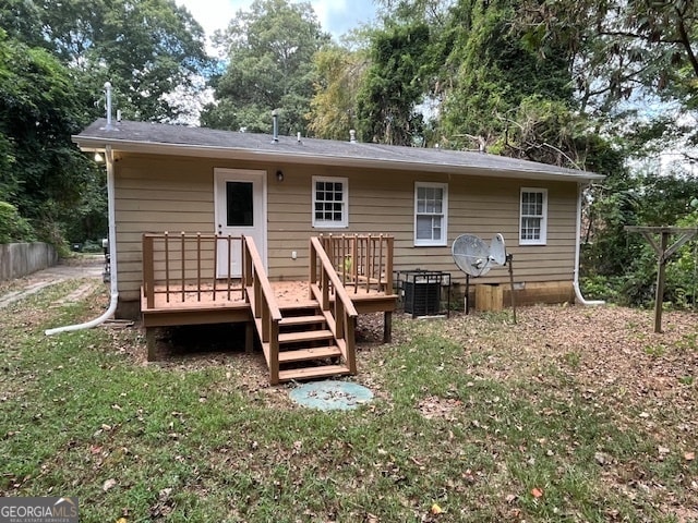 rear view of house with a yard and a wooden deck