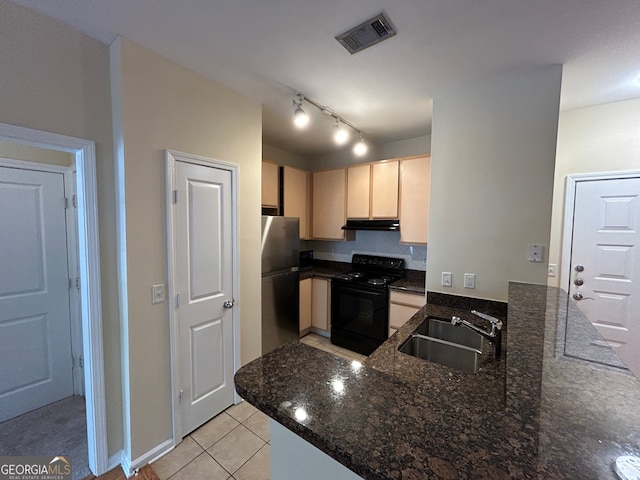 kitchen featuring dark stone counters, sink, kitchen peninsula, stainless steel refrigerator, and black range with electric cooktop