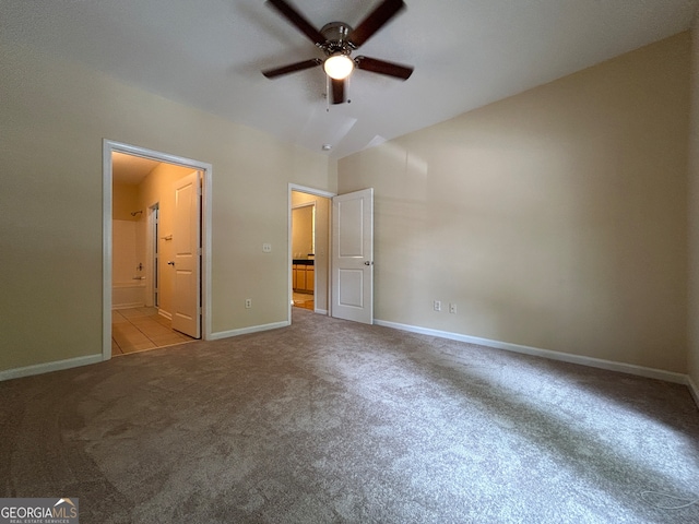 unfurnished bedroom featuring ceiling fan, lofted ceiling, light carpet, and ensuite bathroom