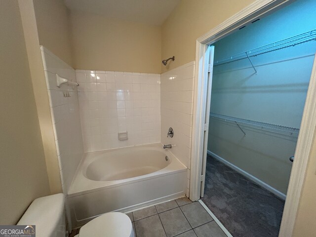 bathroom with toilet, bathtub / shower combination, and tile patterned floors