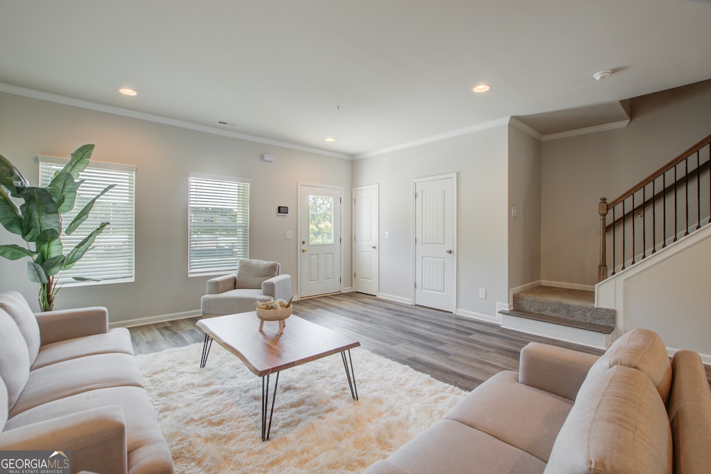 living room with light hardwood / wood-style flooring and crown molding