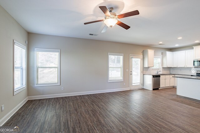 kitchen with a wealth of natural light, white cabinets, and appliances with stainless steel finishes