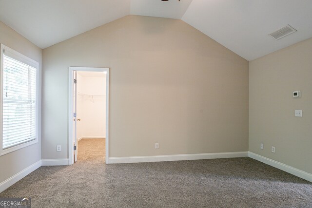 unfurnished room with carpet flooring, vaulted ceiling, and ceiling fan