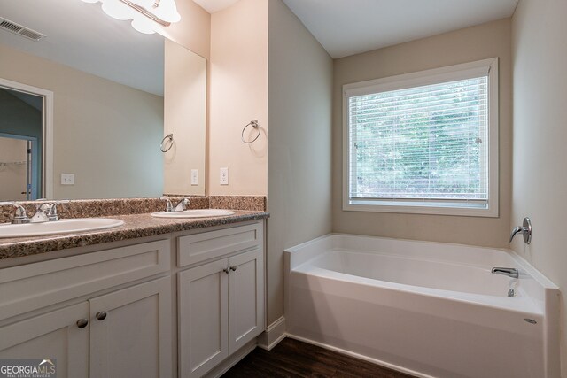 bathroom featuring vanity, hardwood / wood-style floors, and a washtub