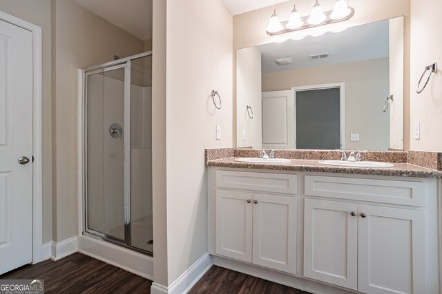 bathroom featuring walk in shower, wood-type flooring, and vanity