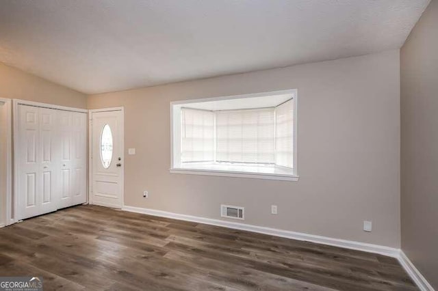 entrance foyer with lofted ceiling, dark hardwood / wood-style floors, and plenty of natural light