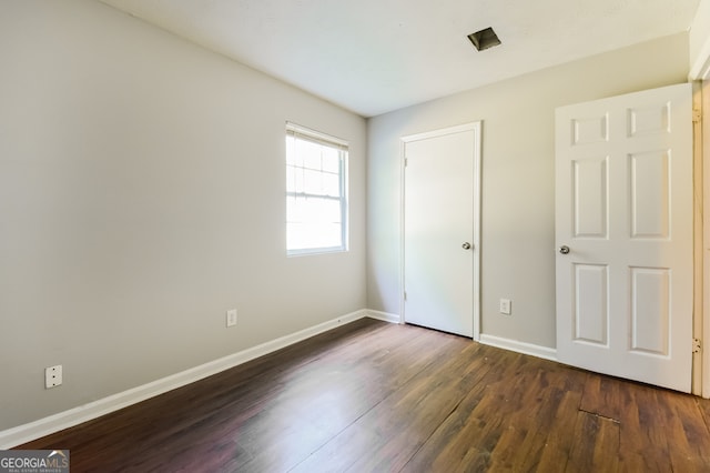 unfurnished bedroom featuring dark wood-type flooring