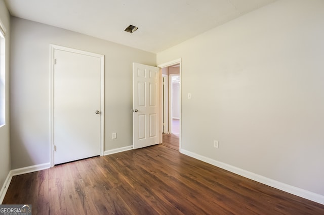 unfurnished bedroom featuring dark hardwood / wood-style floors