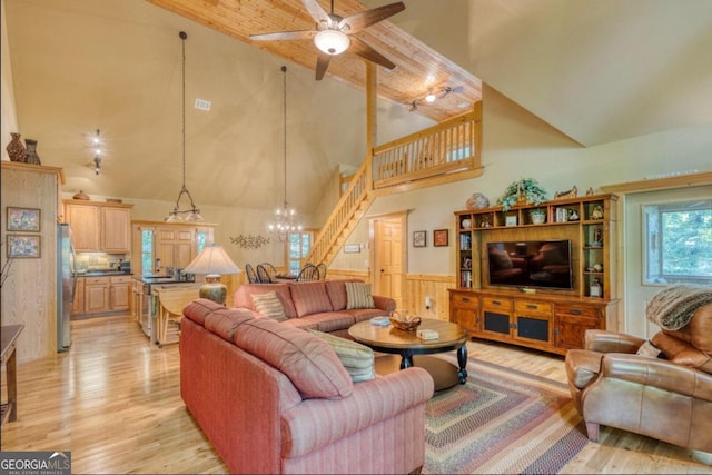 living room featuring ceiling fan with notable chandelier, high vaulted ceiling, and light hardwood / wood-style flooring