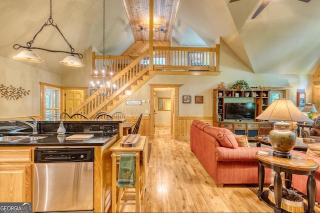 interior space with sink, stainless steel dishwasher, decorative light fixtures, an inviting chandelier, and light hardwood / wood-style floors