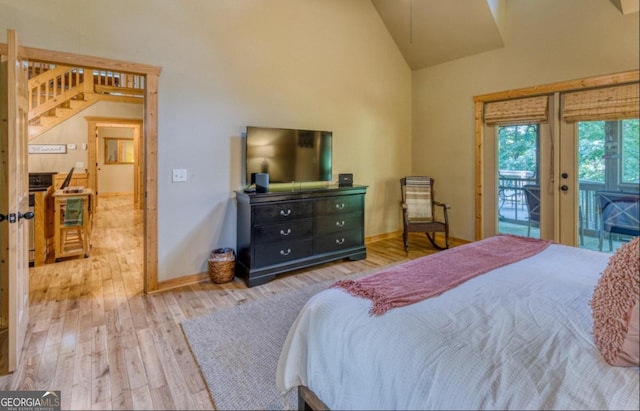 bedroom featuring high vaulted ceiling, light hardwood / wood-style floors, and access to exterior