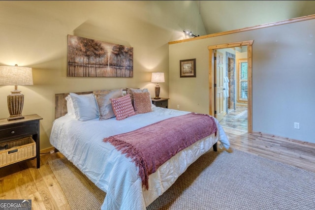 bedroom featuring light hardwood / wood-style flooring and lofted ceiling