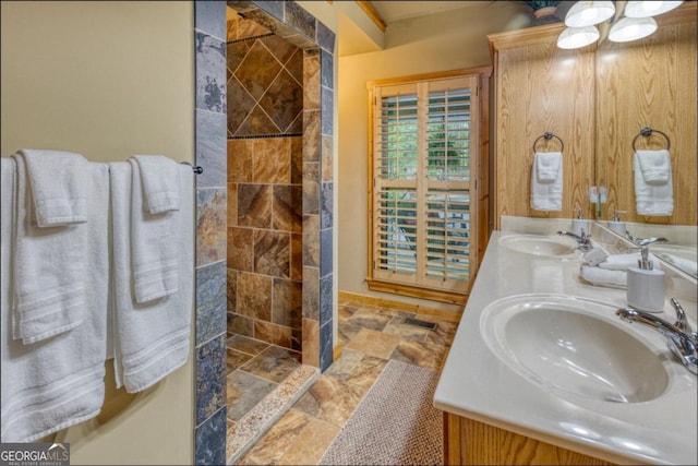 bathroom featuring tiled shower and vanity