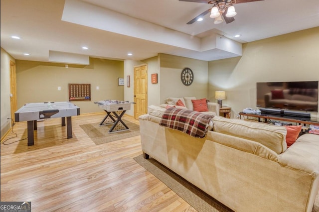 living room featuring light hardwood / wood-style flooring and ceiling fan