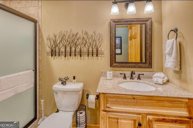 bathroom with walk in shower, vanity, and toilet