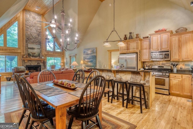 dining space with a wealth of natural light, an inviting chandelier, and high vaulted ceiling