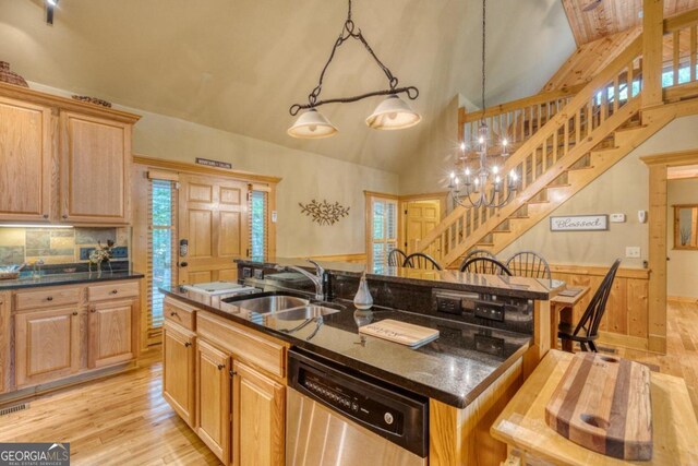 kitchen featuring hanging light fixtures, dishwasher, light wood-type flooring, a center island with sink, and sink