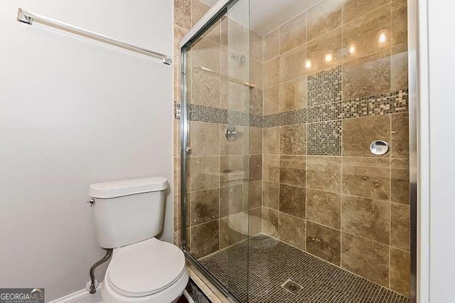 bathroom with toilet and an enclosed shower